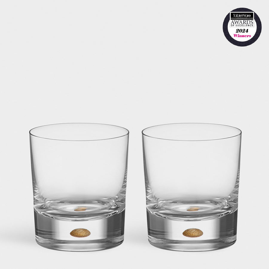 Two Orrefors Intermezzo Gold Old Fashioned 8.5oz tumblers, designed by Erika Lagerbielke and adorned with a gold dot design, are set against a plain background. These mouth-blown glass pieces display the Ideal Home Awards 2021 Winner badge in the top right corner.