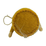 Round yellow wool ornament with visible white fibers, two simple wooden legs, and an attached hanging string, shown from the bottom angle.