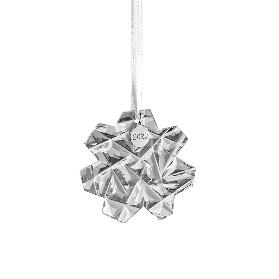 The Orrefors Annual Ornament Carat is a stunning crystal star-shaped ornament featuring a ribbon and a metal tag engraved with 2022.