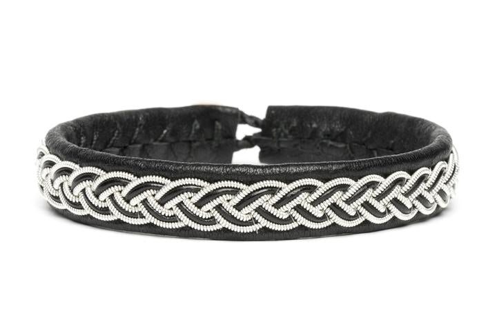 The Sami Otto Black bracelet, measuring 16.5cm, is crafted from luxurious reindeer leather and features hand-sewn detailing with a silver braided pattern.