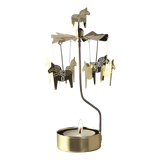 Gold Swedish rotary candle holder with Dala horse silhouettes and a lit tea light.