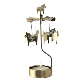 Gold Swedish rotary candle holder with Dala horse silhouettes and a lit tea light.