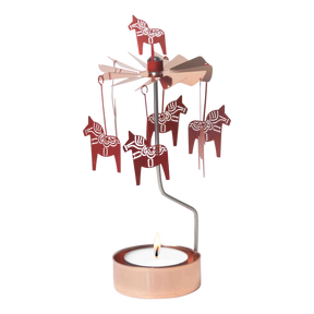 Rose gold Dala Horse metal figures spin on a rotary candle holder above a tealight in a copper holder, shown against a plain white background.