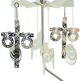 Scandinavian-style rotary candle holder with four hanging metal ornaments, including cross designs with wreath accents, shown against a white background.