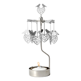 Rotary candle holder with love bird and heart shapes suspended above a lit tealight, all crafted from silver-toned recycled metal.