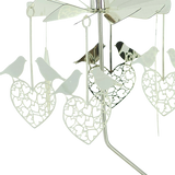 Rotary candle holder with silver finish, featuring intricate cutouts and hanging ornaments shaped like love birds and hearts.
