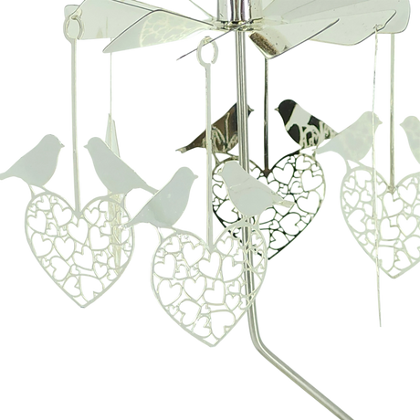 Rotary candle holder with silver finish, featuring intricate cutouts and hanging ornaments shaped like love birds and hearts.