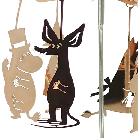 Metal cutouts featuring a top-hatted Moomin character and a black dog-like figure hanging from a reflective rod.