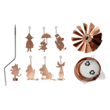 Rose gold Moomin family charms, a metal rod, spinning fan blade, candle holder parts, and two tealight candles arranged on a white background.