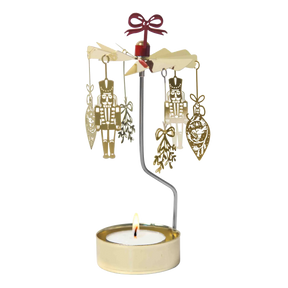 Gold-colored Swedish rotary candle holder featuring hanging nutcracker and ornament silhouettes, topped with a red bow.