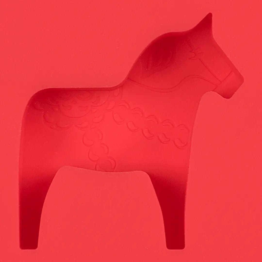 The Candy Mold: Dalahast Pralinform features a red Dala horse silhouette against a vibrant red background, adorned with kurbits detailing and delicate decorative patterns.