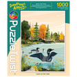1000-piece puzzle showing Minnesota loons swimming on a lake beneath pale clouds, with trees in fall colors. Artwork by Tim Chapman visible on the box.