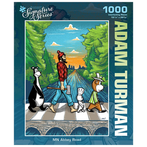Puzzle box featuring a man and three cartoon animals crossing a road Abbey Road-style, with trees and a sunset in the background. “Adam Turman” visible on the box.