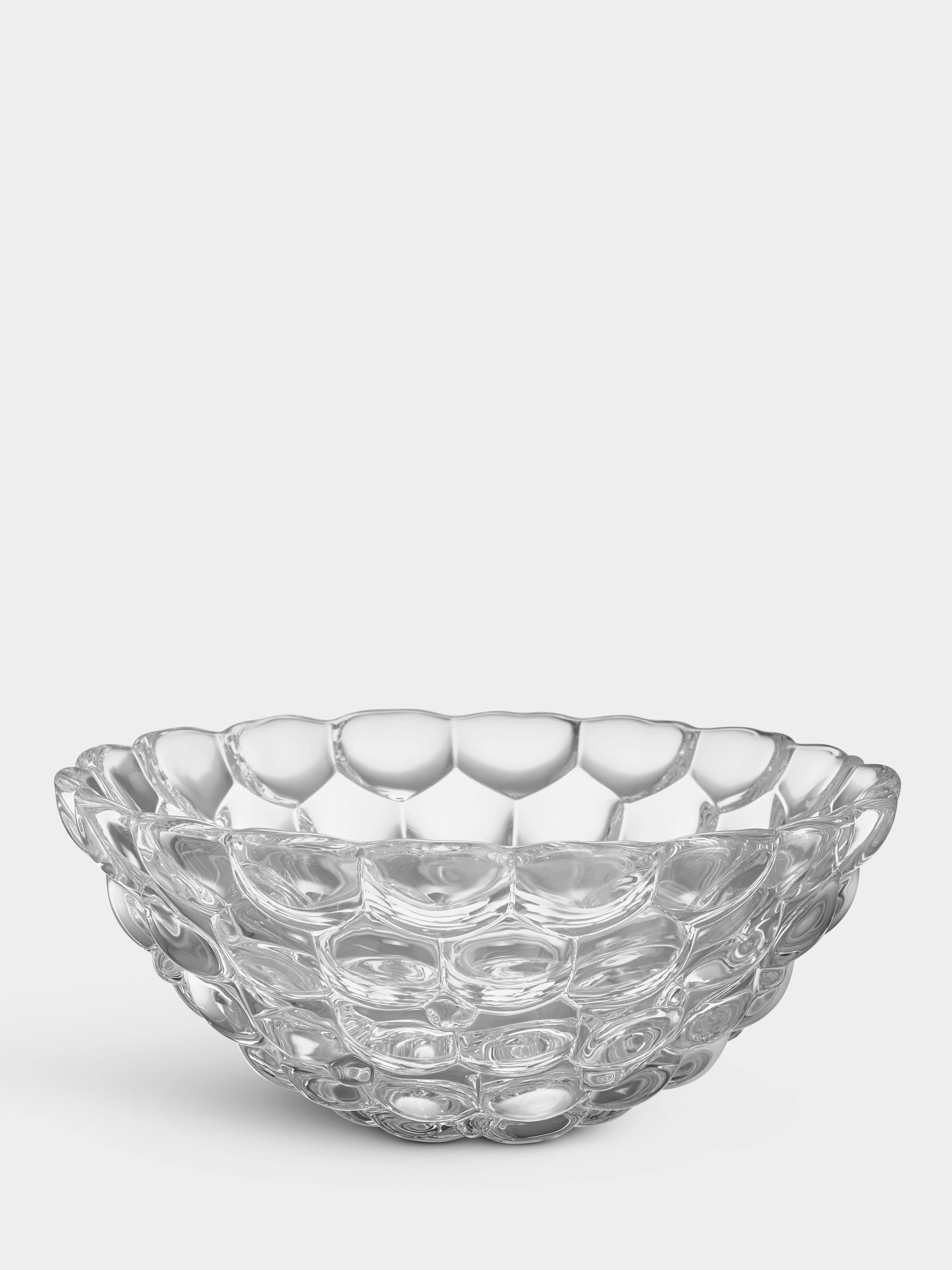 The Orrefors Raspberry Bowl Small features a crystal-clear, honeycomb-like pattern that gives it a delicate appearance.