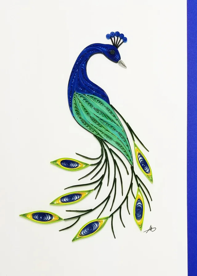 The Cards: Peacock Quilling Card displays an intricately designed quilled paper art of a vibrant peacock, featuring blue, green, and yellow feathers against a white background with a blue border.