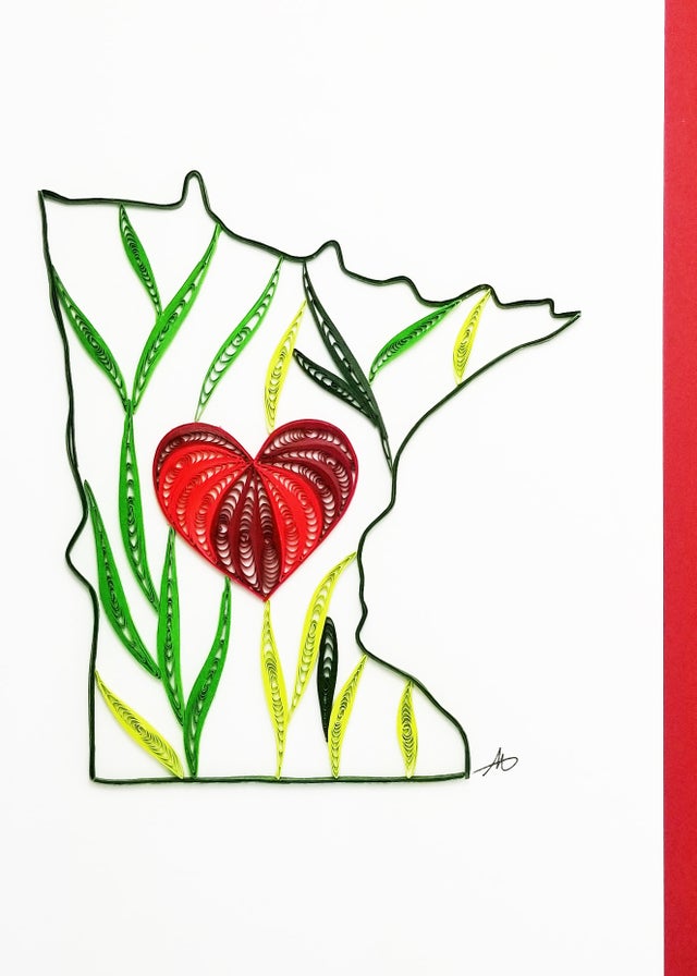 The "Cards: Minnesota Quilling Card" showcases a hand-crafted depiction of Minnesota's outline, adorned with intricate green leaves and a central red heart.