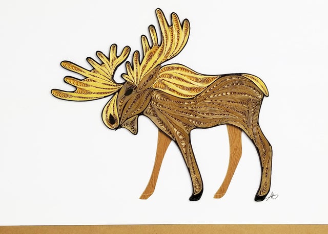 The Cards: Moose Quilling Card 5x7 showcases hand-crafted quilled paper art of a moose, with shades of brown and yellow on a white background, evoking the natural beauty of Minnesota.