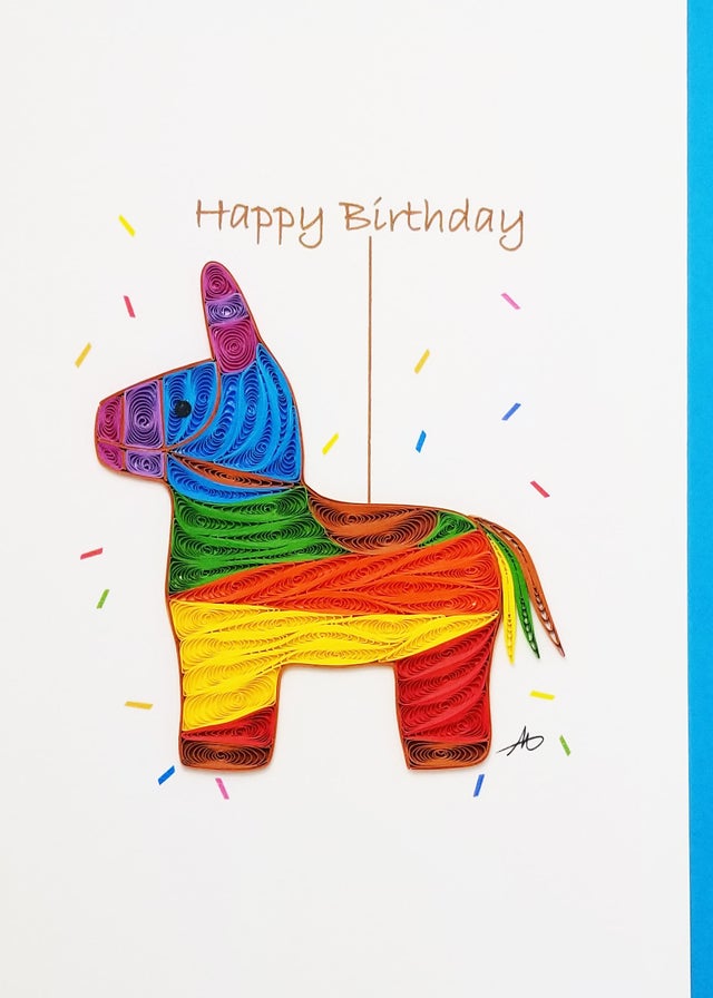 A vibrant Dala Birthday Quilling card, crafted in Minnesota, features a meticulously paper-quilled donkey piñata with the words "Happy Birthday" elegantly displayed on a crisp white background.
