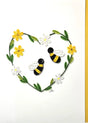 The Bees with Daisy Flowers Heart Quilling Card 5x7 features two bees inside a heart of green leaves and yellow-white flowers—an ideal handmade card for any special occasion.