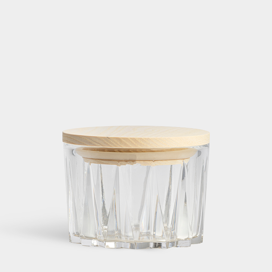 The Orrefors: Sarek Bowl with Lid is a clear glass jar with vertical ridges and a wooden lid, inspired by Swedish nature, on a plain white background.