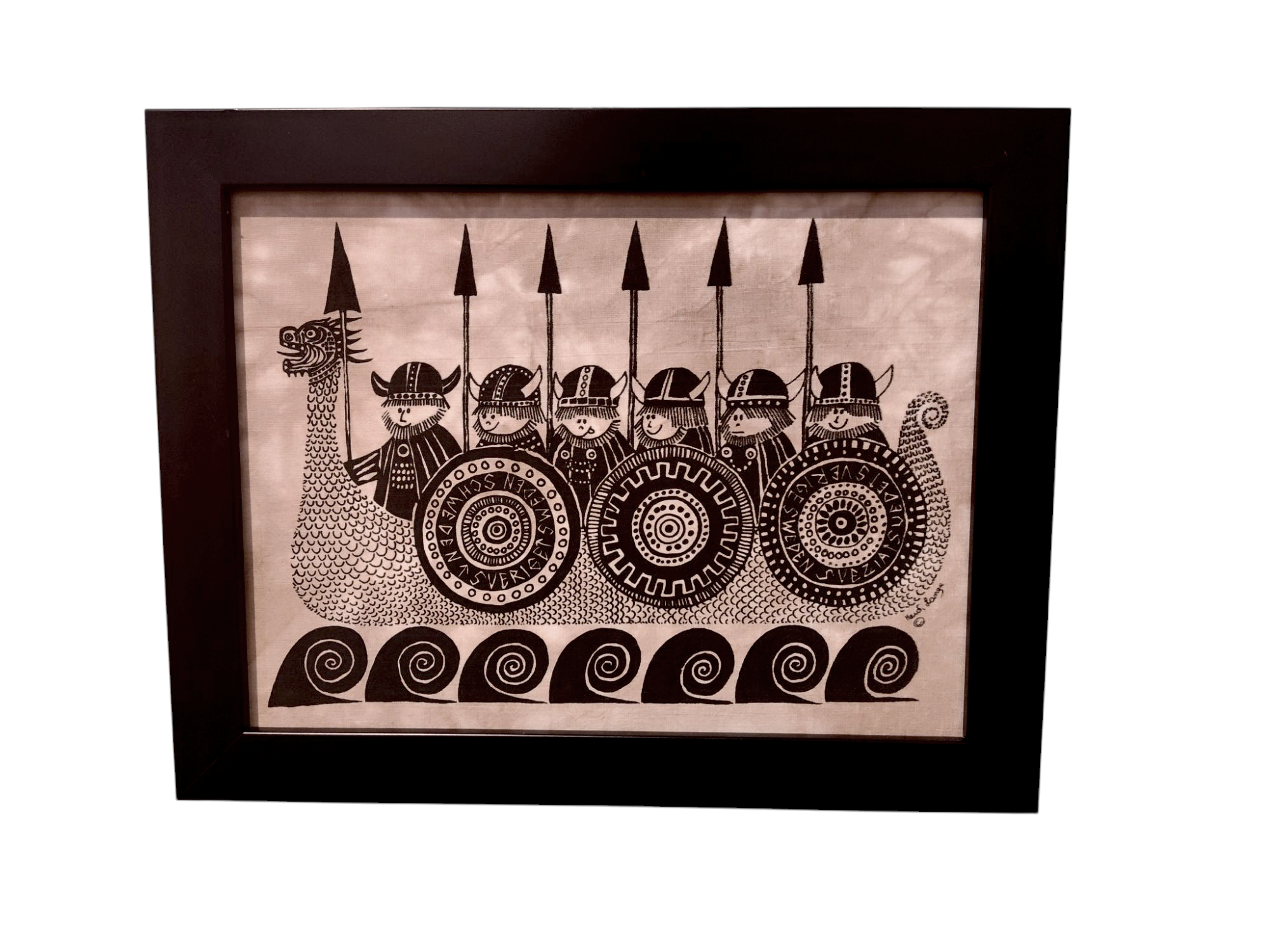 This black and white artwork, reminiscent of Heidi Langes style, features six helmeted figures on a Viking longship. They hold spears and patterned shields, framed elegantly in an 11x14 black frame as part of the Happy Vikings Framed Batik Artwork series.