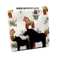 A pair of black Dala horse silhouettes elegantly adorn the Napkin Holder: Dala Horses, which beautifully displays a patterned napkin featuring vibrant Dala horse designs, exemplifying top-notch Swedish craftsmanship.