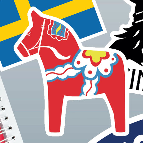 Sticker of a Swedish Dala horse with Scandinavian patterns next to a Swedish flag sticker on a gray background.