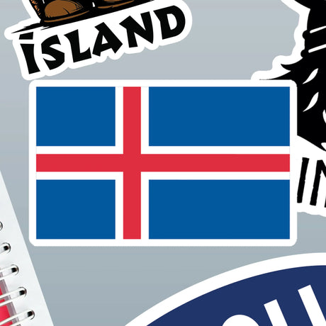 Iceland flag sticker with a blue background and red cross outlined in white, surrounded by other Nordic-themed stickers on a gray surface.