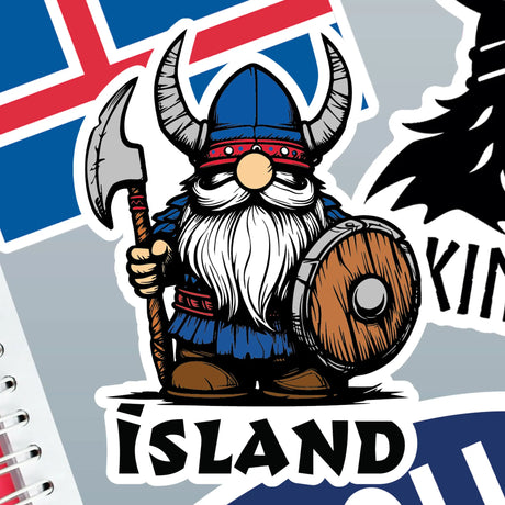 Cartoon Viking with helmet, axe, and shield stands in front of the Iceland flag; “Island” appears in bold letters below. Sticker design.