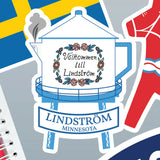Sticker showing the Lindström Water Tower, the text “Välkommen till Lindström,” Swedish flags, and colorful Scandinavian-inspired graphics.