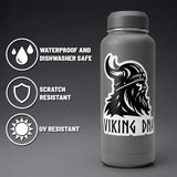 A gray water bottle adorned with the “Nordic Sticker: Viking DNA Sticker – Unleash Your Inner Warrior” from Swedish Gift Store, featuring a bold Viking helmet design. Icons show this 3.45 x 4-inch sticker is waterproof, dishwasher safe, scratch resistant, and UV resistant.