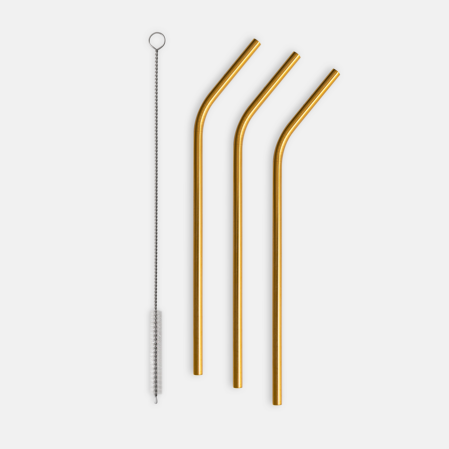 The Orrefors Peak Cocktail Straws 4-Pack features three gold stainless steel straws and a handy cleaning brush, presented on a pristine white backdrop.