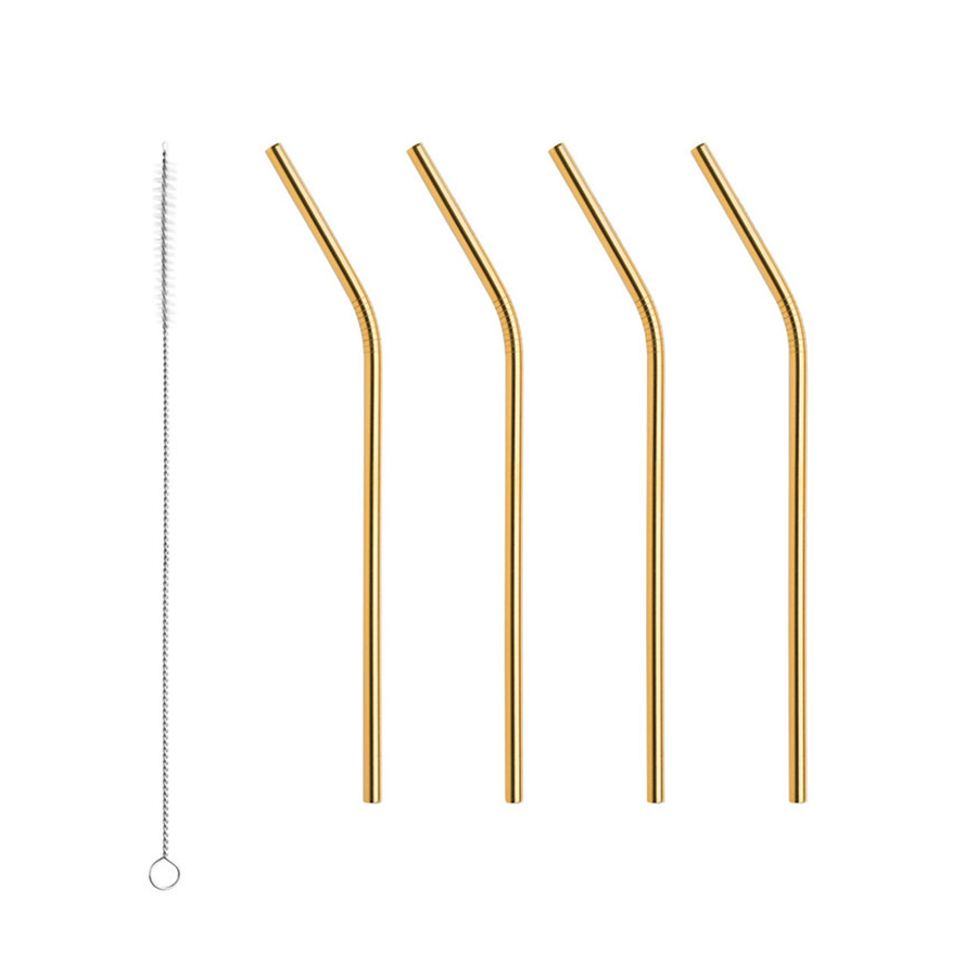 Four stainless steel Orrefors Peak Cocktail Straws in gold are arranged vertically next to a thin cleaning brush on a pristine white background.