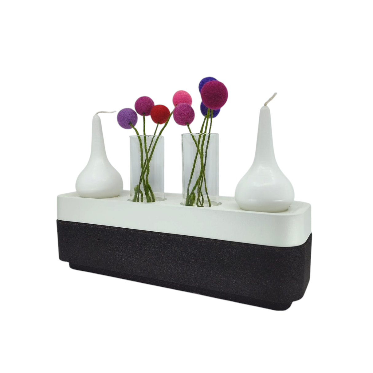 A modern vase with three glass tubes holding colorful artificial flowers stands beside two Stumpastaken Swedish Candle Holders, all displayed on a sleek black and white rectangular base.