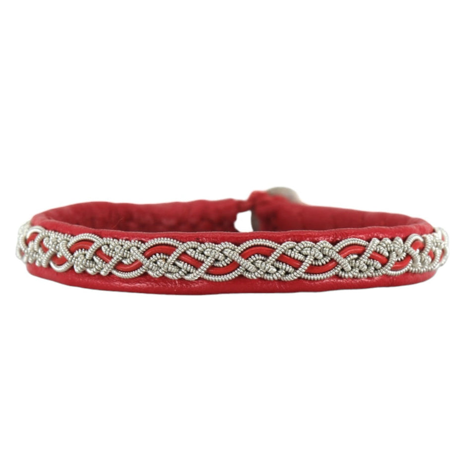 The Sami Svea Red bracelet is hand-braided with silver detailing and features a reindeer antler button, elegantly displayed against a white background.