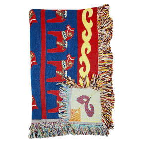Woven blanket with red, blue, and yellow patterns, Swedish Dala horse designs, multicolored fringes, and a visible square patch.