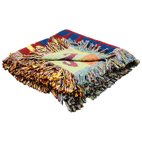 Folded multicolored woven blanket with fringed edges, displaying bright geometric patterns inspired by Scandinavian textiles.