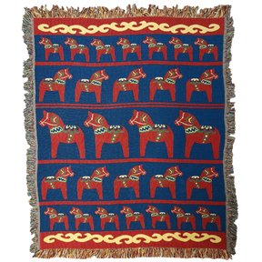 The Swedish Passport Co Blanket: Swedish Dala Horse 100% Cotton Woven Blanket (50"x60") features rows of red Dala horses and yellow fringe on a blue background—an ideal Nordic decor accent.