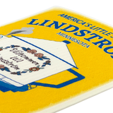 Close-up of a Swedish dishcloth with a floral teapot design and the visible text “Americas Little Sweden” on a bright yellow background.