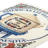 Beige teapot-shaped water tower with floral accents, partial text “AMERICAS LITTLEST,” and a Swedish dishcloth displayed next to it.
