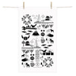 The Made in Sweden Terry-Cotton Towel by Anneko Design Sweden, featuring black Scandinavian-style illustrations on white cotton, including birds, trees, houses, and the iconic Dala horse, hangs on a clothesline with wooden clothespins.