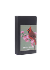 A black box with a Candle Holder: Pluto Design Cardinal Gold and Red Angel Chime label, displaying a cardinal on a cherry blossom branch, epitomizes elegance like an exquisite rotary candle holder.