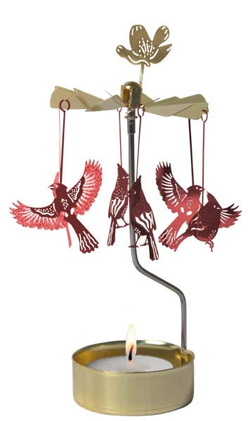 A Pluto Design Cardinal Gold and Red Angel Chime rotary candle holder with bird silhouettes hangs elegantly above a lit tealight, casting enchanting shadows in every direction.