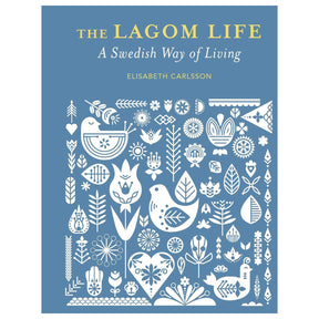 Book: The Lagom Life: A Swedish Way of Living by Elisabeth Carlsson features white folk art birds, flowers, and leaves on a blue cover, capturing the spirit of lagom and Swedish living.