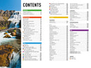 The table of contents page showcases vibrant sections, covering topics from travel tips to regional guides. A scenic waterfall photo enhances the left side, reminiscent of a book like Insight Guides Iceland.