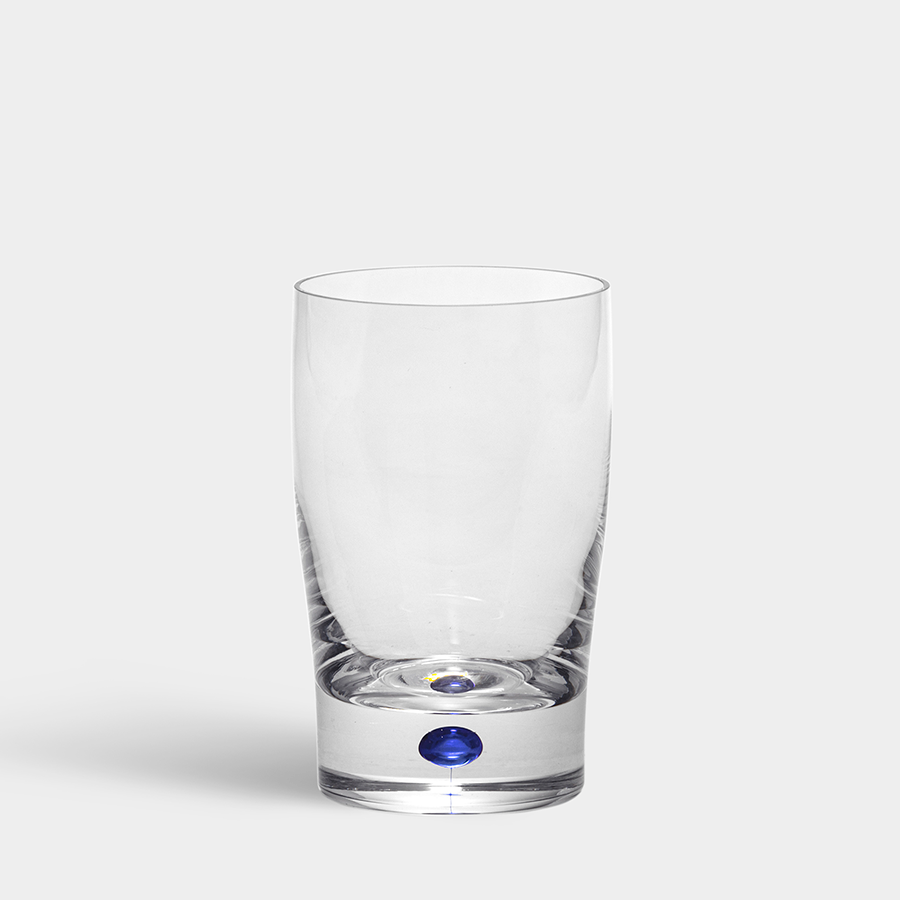 The Orrefors: Intermezzo Blue Tumbler/Juice 9oz, crafted by Erika Lagerbielke, showcases clear glass with a striking blue accent at the base.