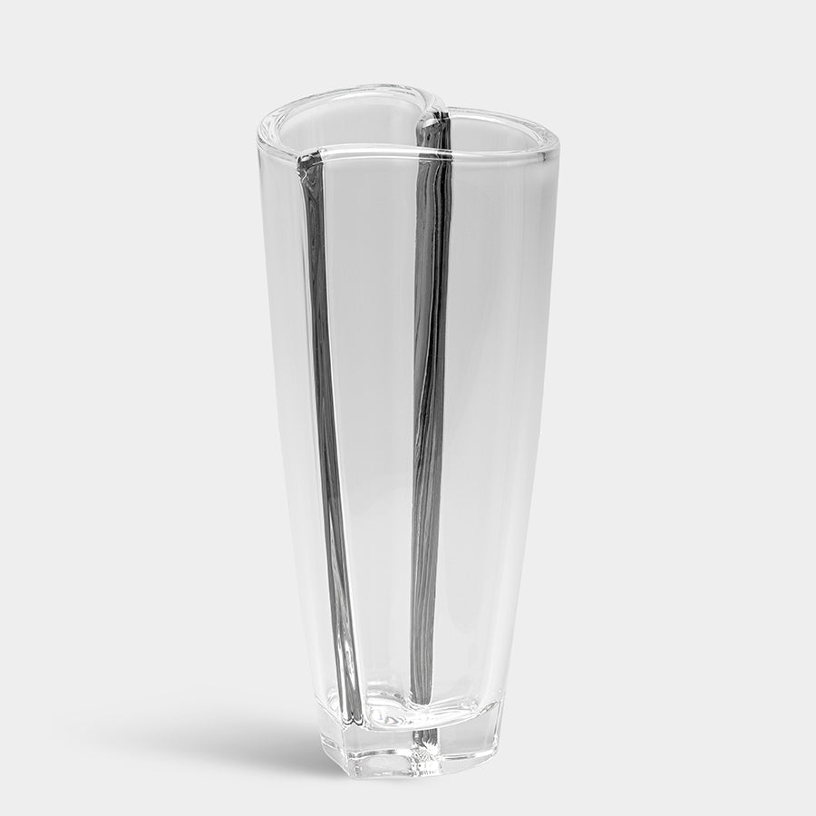 The Orrefors: Heart Bud Vase Large is an elegant piece featuring a tall, clear crystal design with a unique wavy pattern, beautifully standing on a white background.