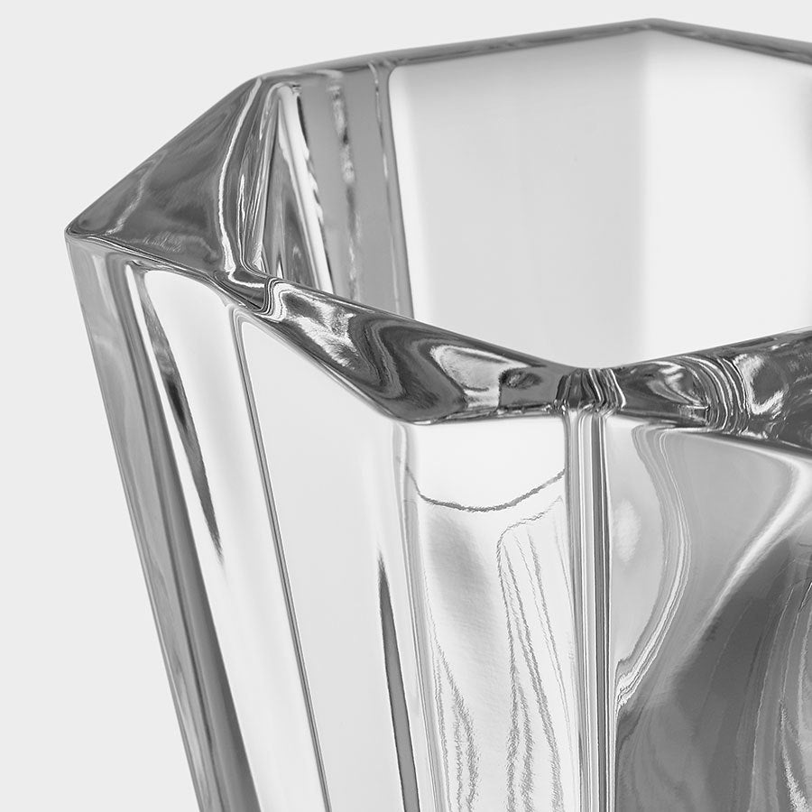 Close-up of the Orrefors: Precious Vase Small by Malin Lindahl, showcasing clear angular glass and geometric facets against a light gray background.