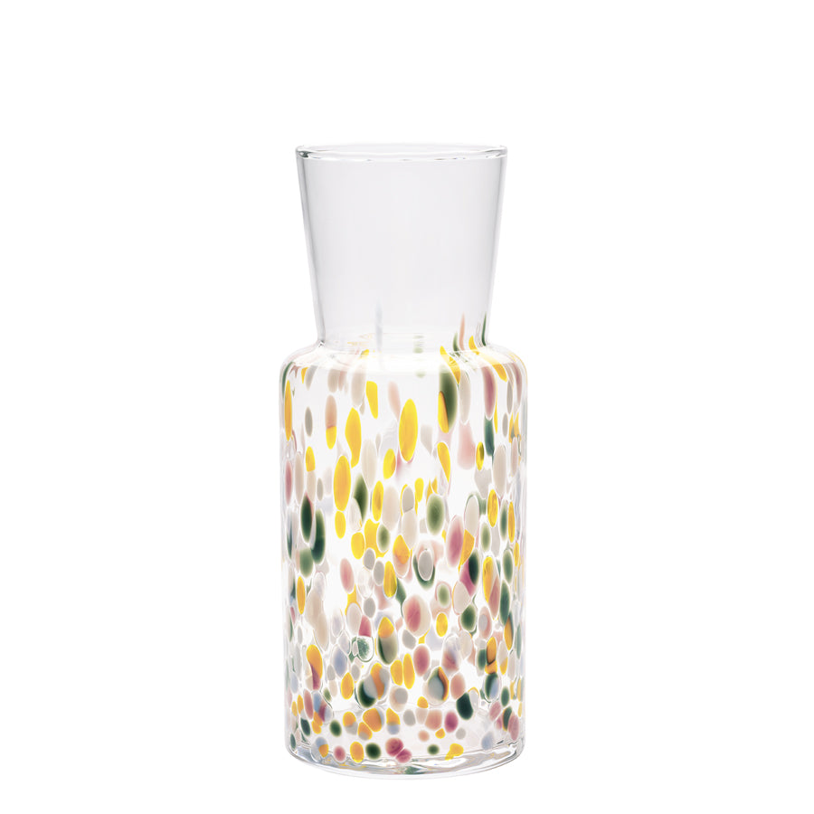 The KostaBoda: Meadow Vase Spring Tall is a clear glass carafe featuring colorful dots in yellow, red, and green. Inspired by the vibrant Meadow Spring tones, it adds a lively touch to any setting with its cylindrical design.