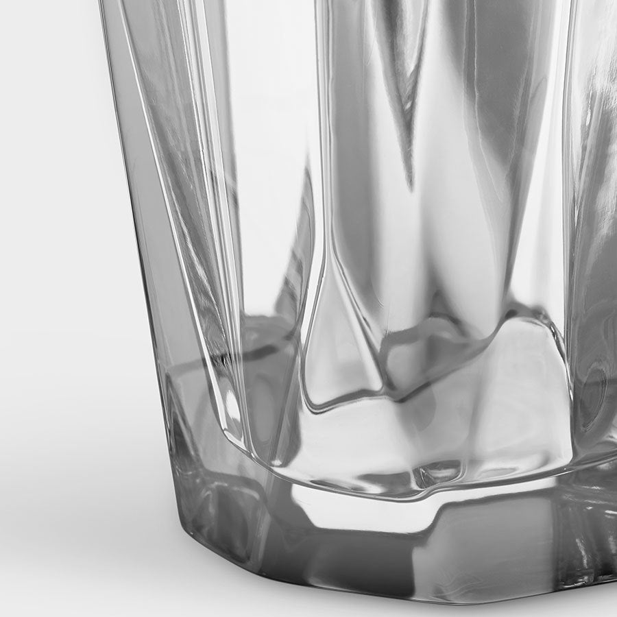 Close-up of the bottom half of a clear, empty, faceted Orrefors: Precious Vase Large with a textured surface.